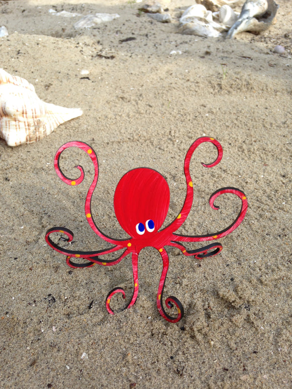 red octopus sculpture on the beach